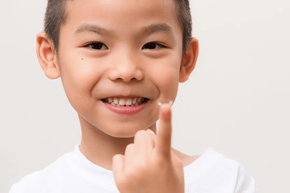 a kid with a contact lens on his finger