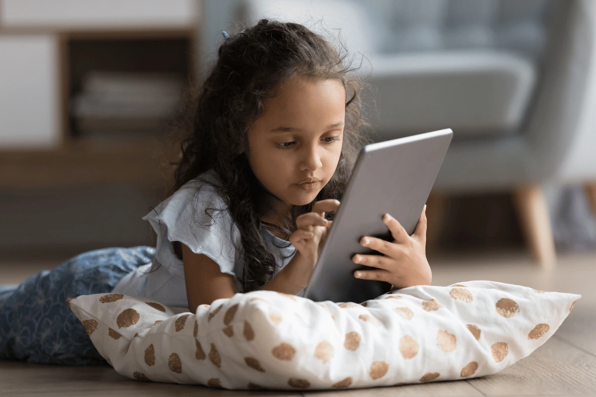 a little girl looking at a tablet