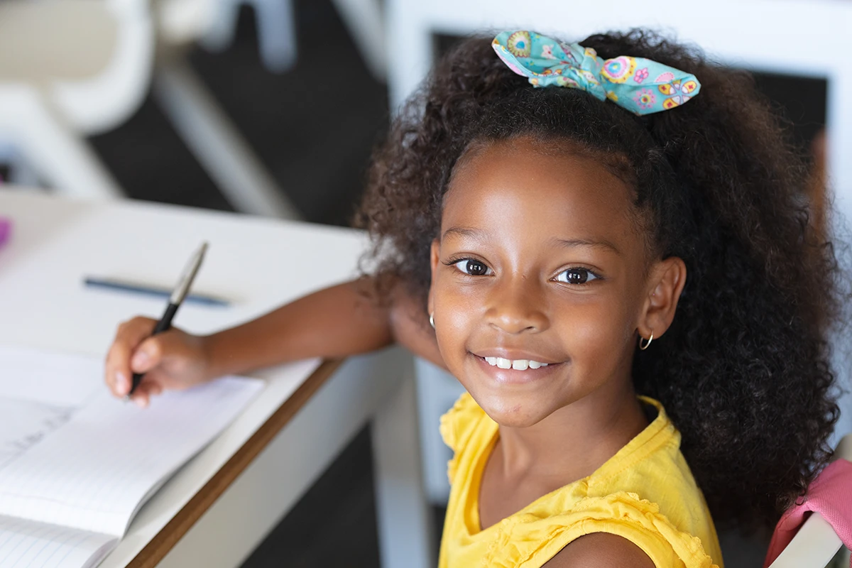 a young girl smiling in the classroom