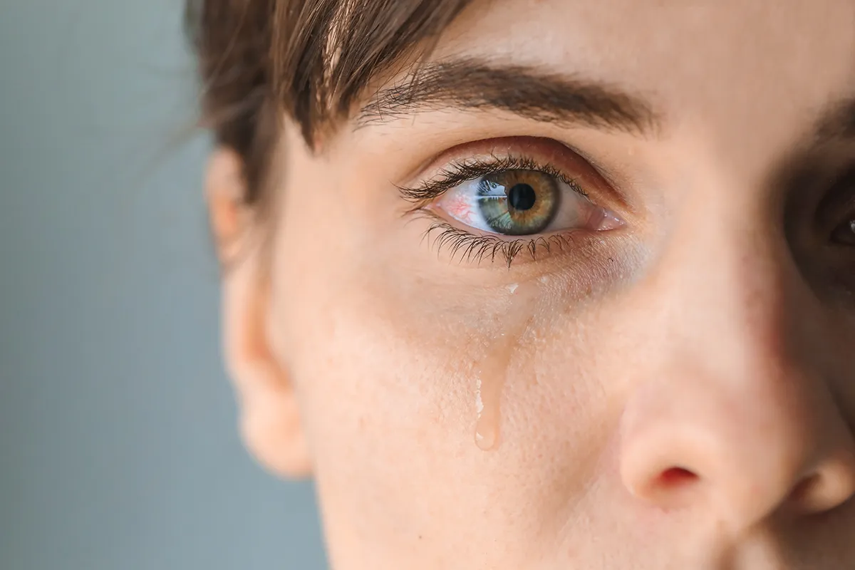 close-up of a woman's face with a teary eye